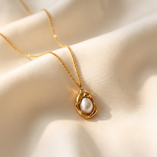 The baroque pearl pendant resting on cream silk