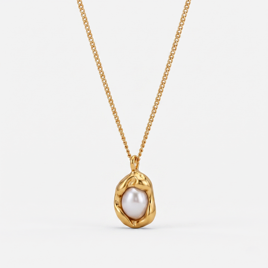 A gold-tone pendant necklace with an irregular imitation pearl in a shaped frame, on a plain background