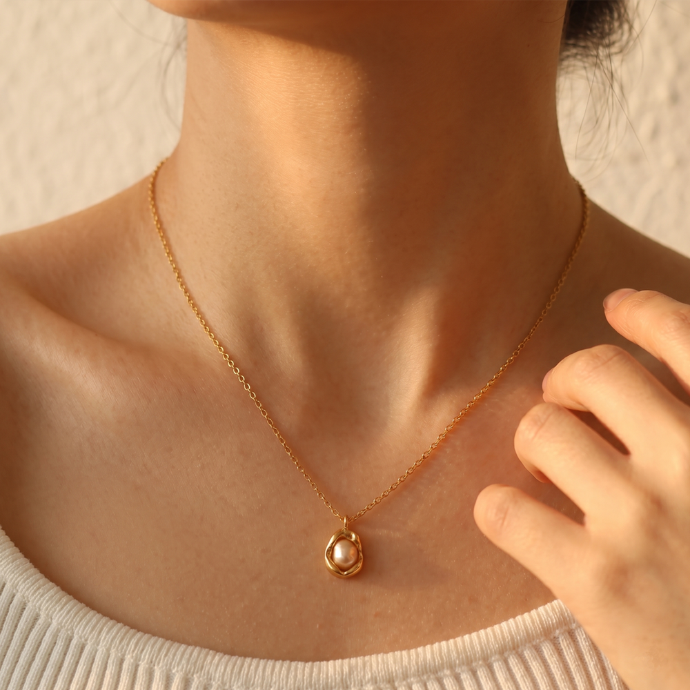 The baroque pendant necklace worn, sitting a little below the collarbone