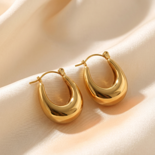 The pair of dome hoops resting on cream silk, showing the hinged closure