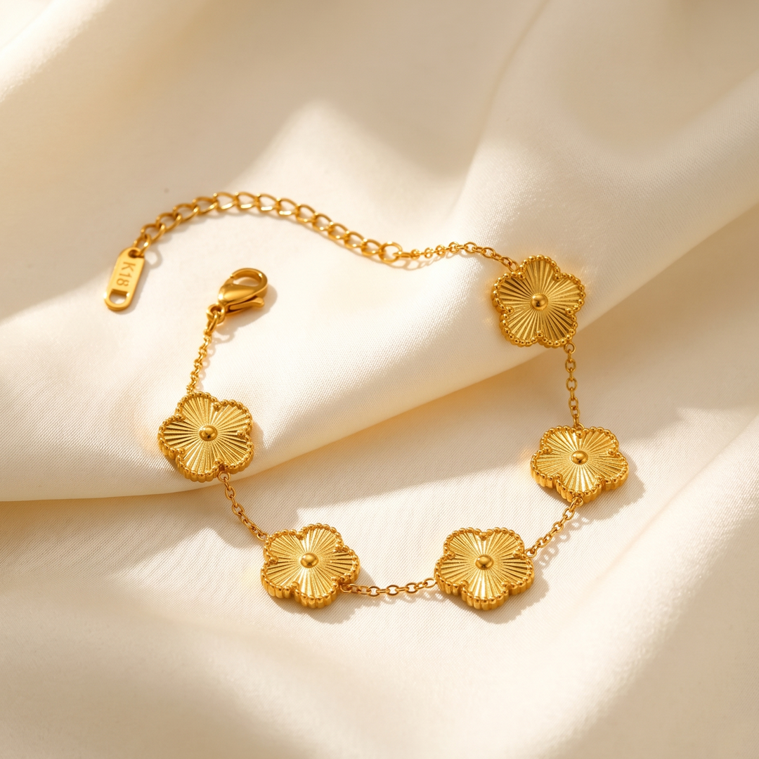 The clover flower bracelet resting on cream silk, showing the clasp and extension