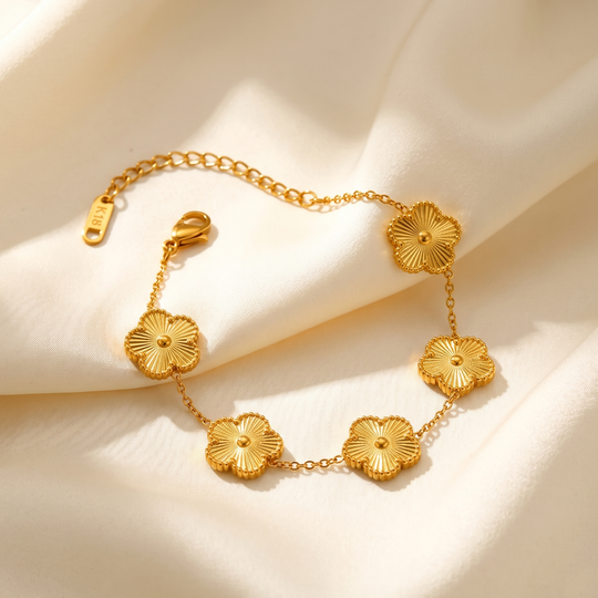 The clover flower bracelet resting on cream silk, showing the clasp and extension