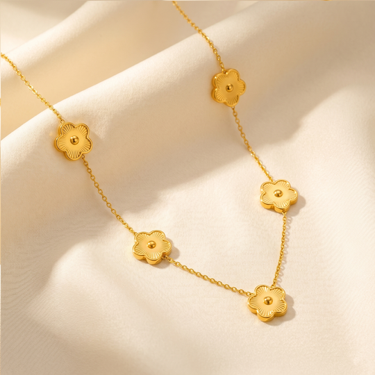 The clover flower necklace resting on cream silk