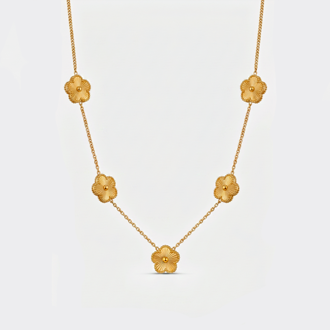 A gold-tone chain necklace with five textured clover flowers, on a plain background