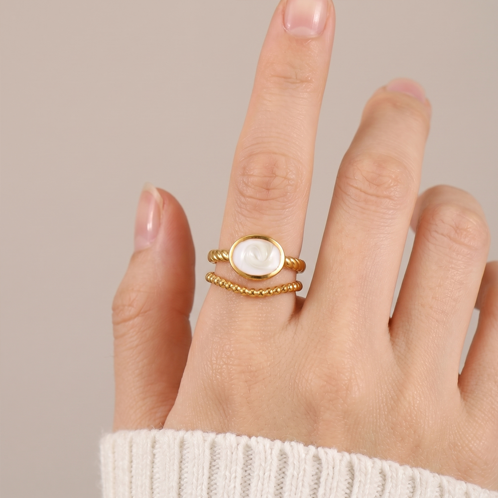 The crest ring worn on the hand, showing the oval inlay across the finger