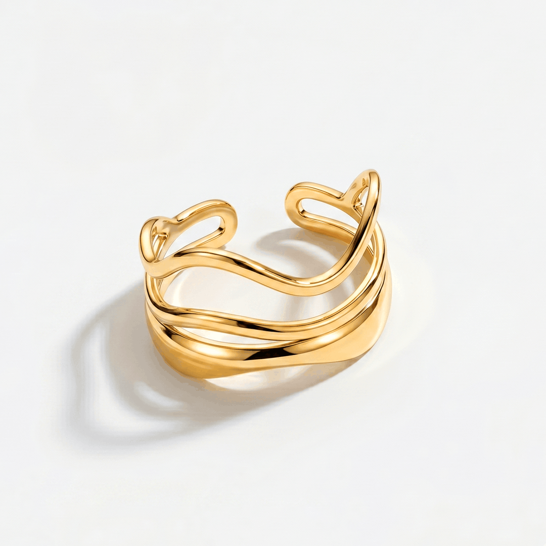 A gold-tone open ring made of two stacked wavy bands, on a plain background