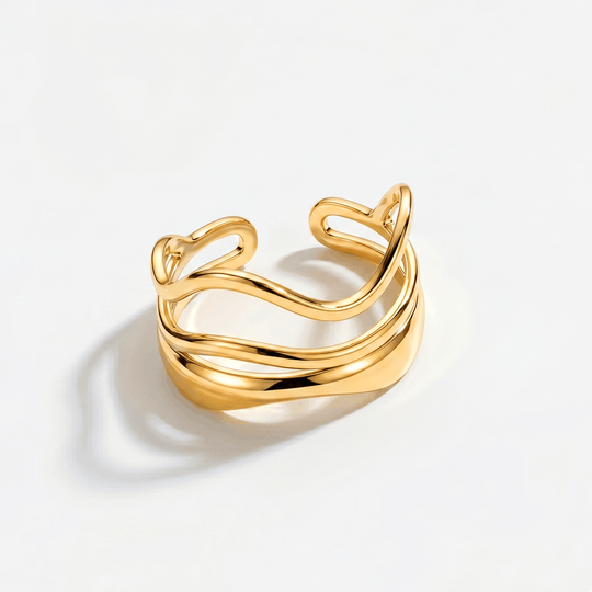 A gold-tone open ring made of two stacked wavy bands, on a plain background