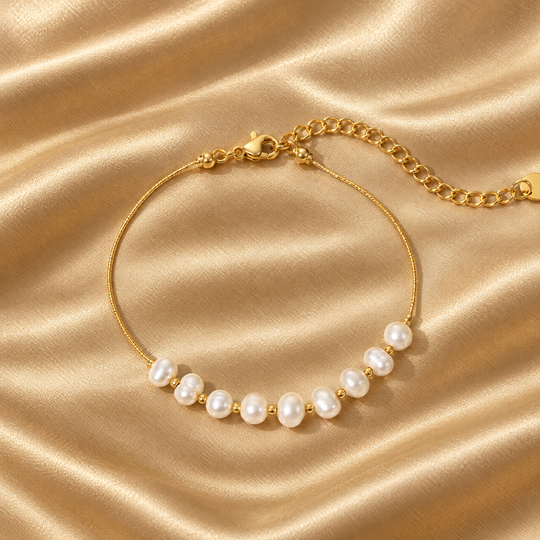 The Lumi Pearl Bracelet resting on champagne satin