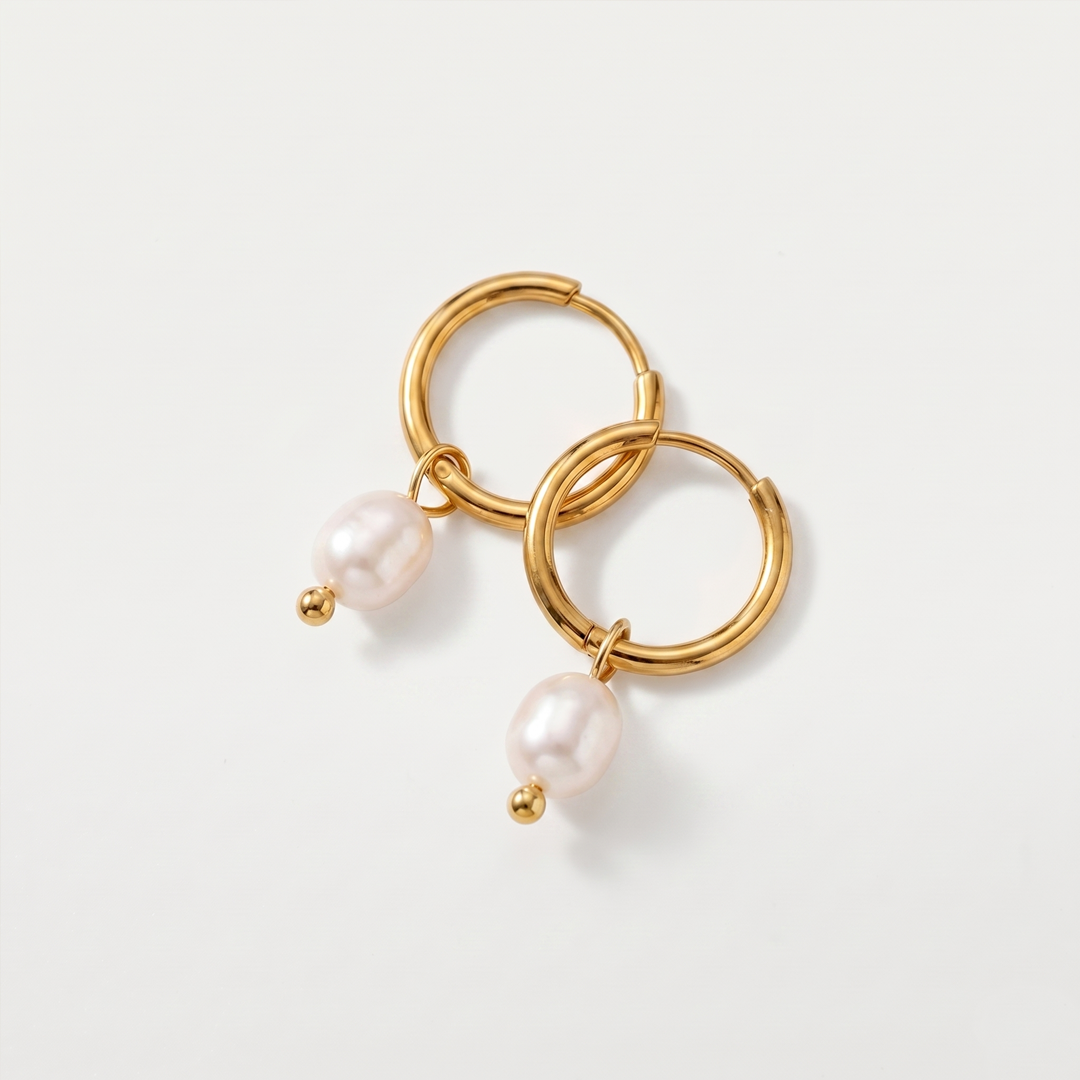Gold-tone hoop earrings with a freshwater pearl drop, shown on a plain background