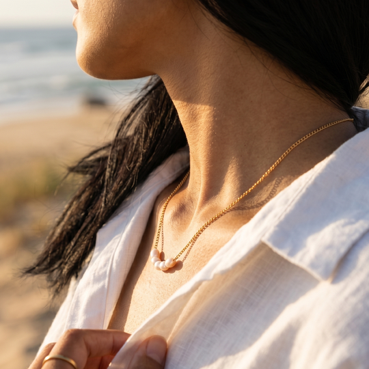 The pearl necklace worn with an open collar