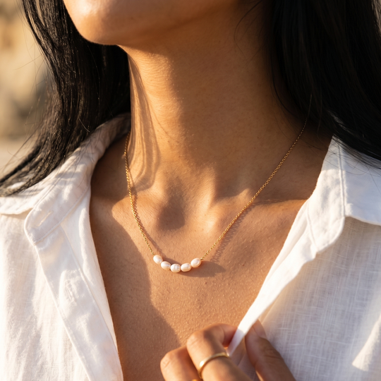 The pearl necklace worn, showing how the row of pearls sits just below the collarbone