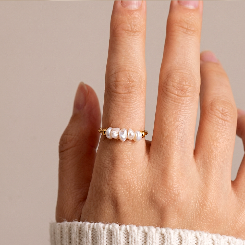 The pearl ring worn on the hand, showing how the row of pearls sits on the finger