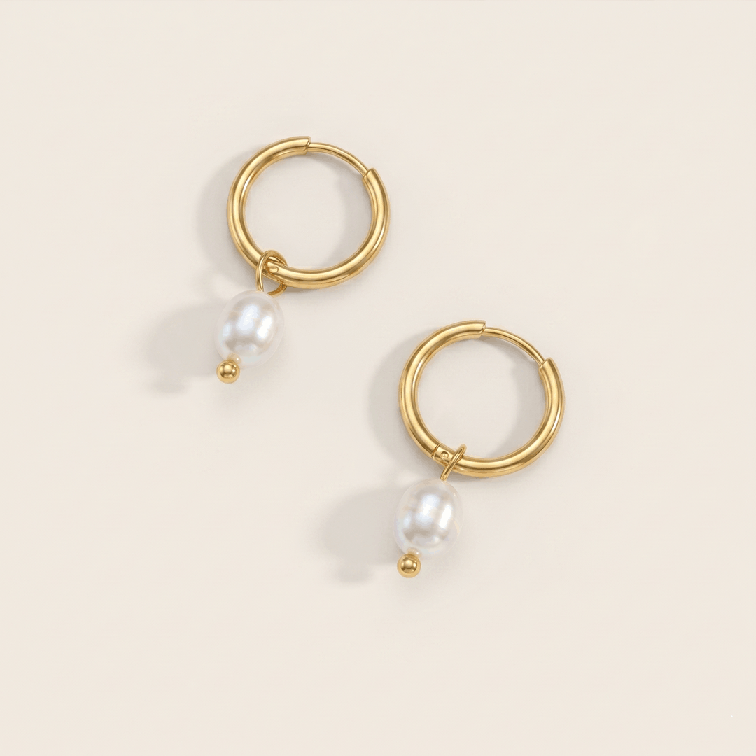A pair of gold-tone hoop earrings, each with a freshwater pearl hanging from the base