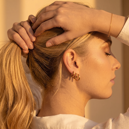 The hoop trio worn together, seen from the side with the hair held back