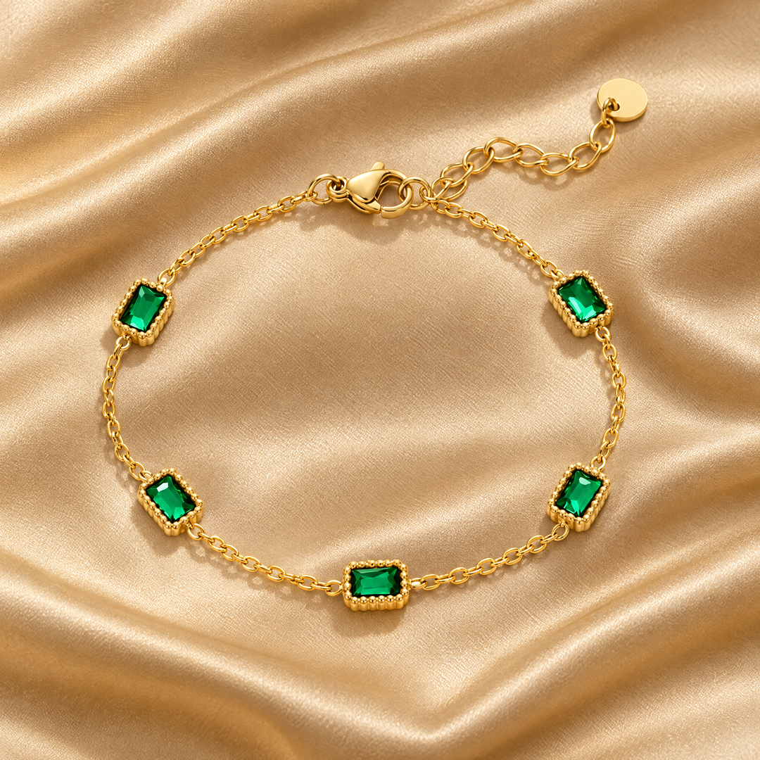 The Ines Green Bracelet resting on champagne satin