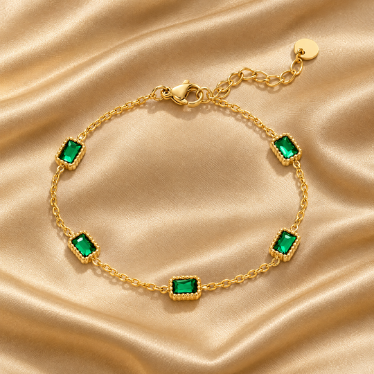The Ines Green Bracelet resting on champagne satin