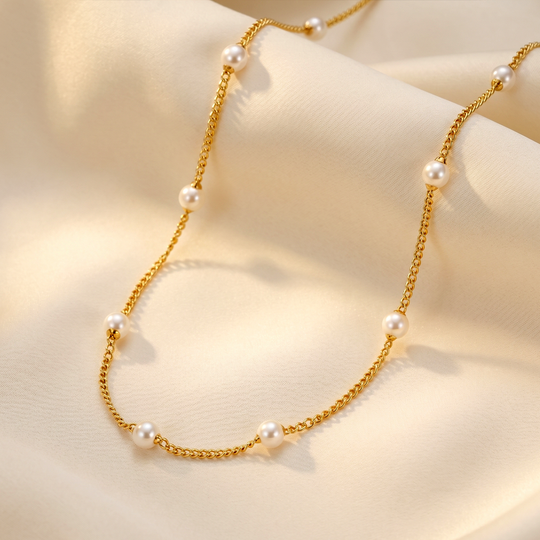 The pearl station necklace resting on cream silk