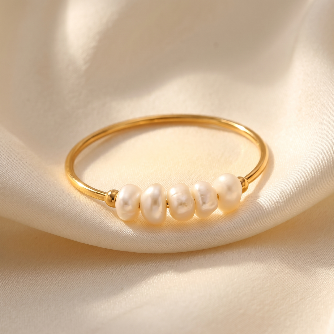 The freshwater pearl ring resting on cream silk