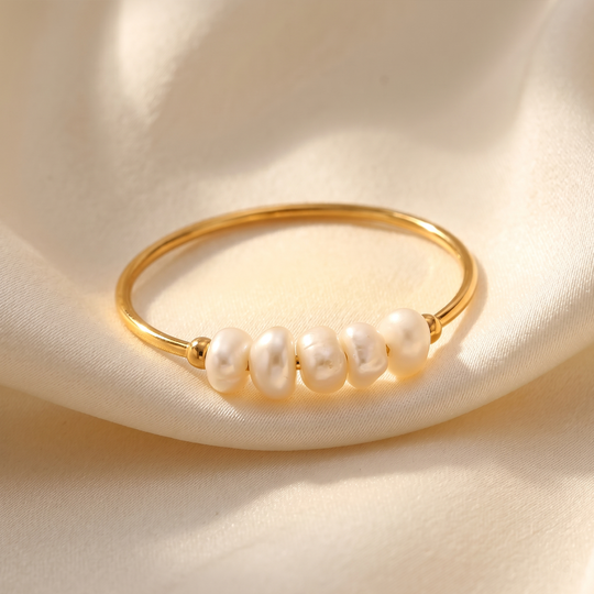 The freshwater pearl ring resting on cream silk