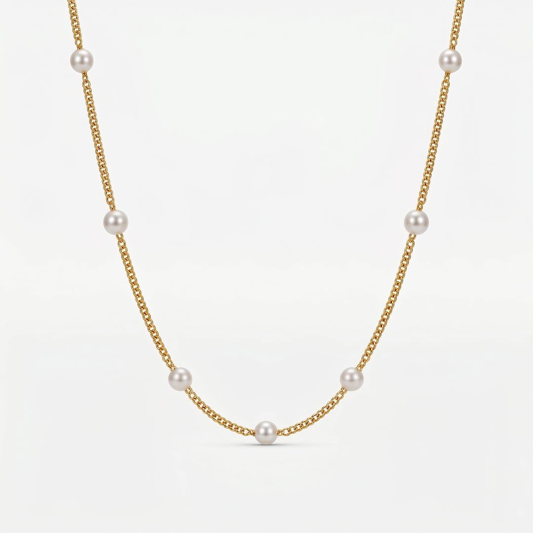 A fine gold-tone chain necklace with small imitation pearls spaced around it, on a plain background