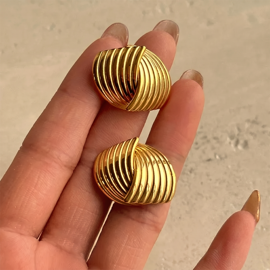 The ribbed studs held in the hand, showing the texture and the post
