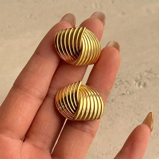 The ribbed studs held in the hand, showing the texture and the post