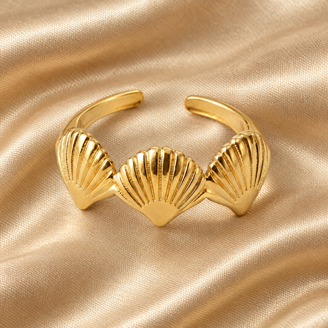 The Bay Scallop Ring resting on champagne satin