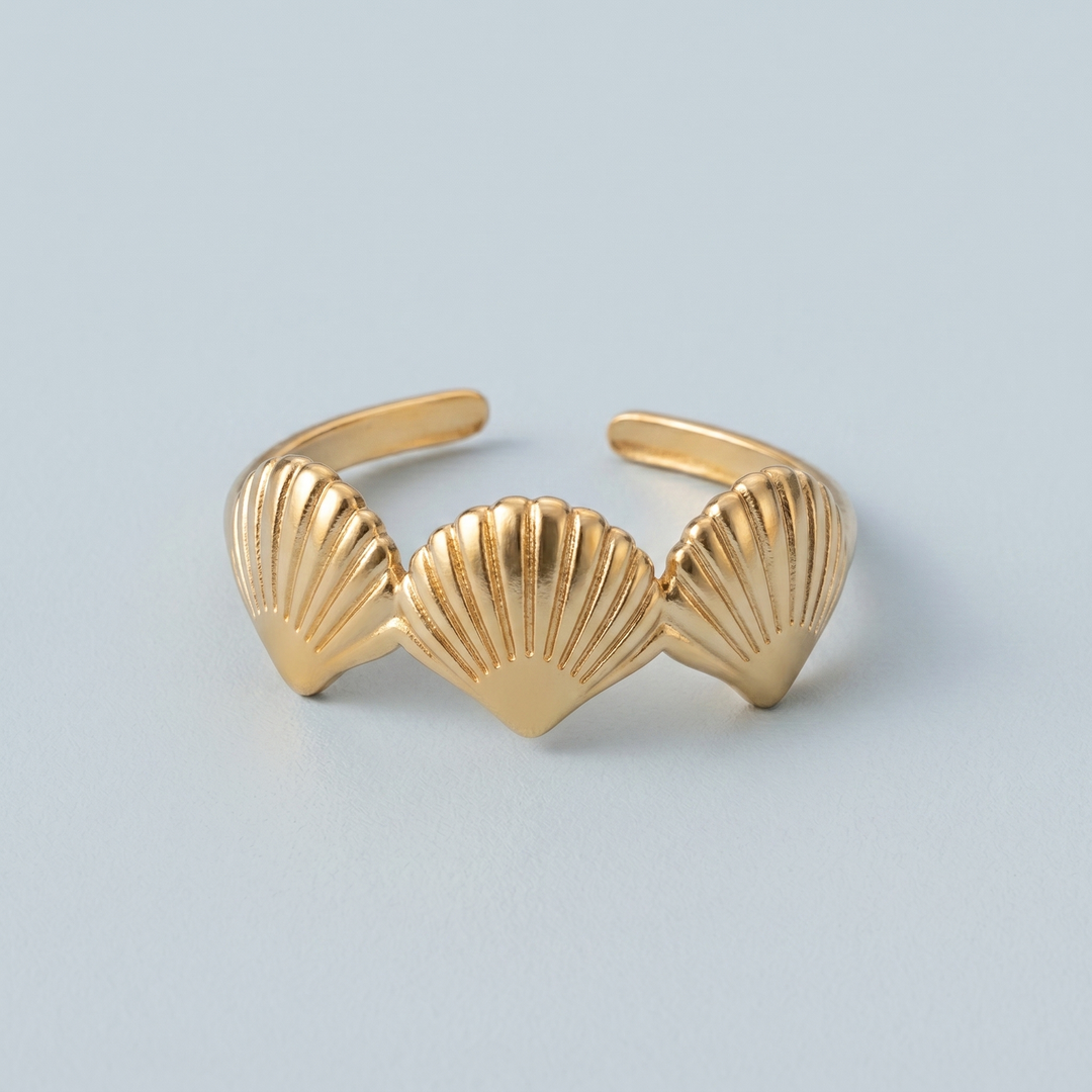 Close detail of the three scallop shells on the gold-tone ring