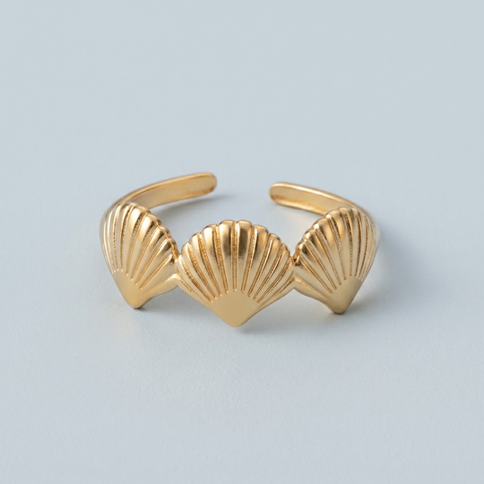 Close detail of the three scallop shells on the gold-tone ring