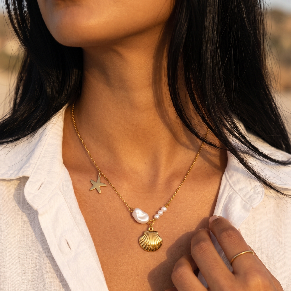 The shell charm necklace worn with an open collar