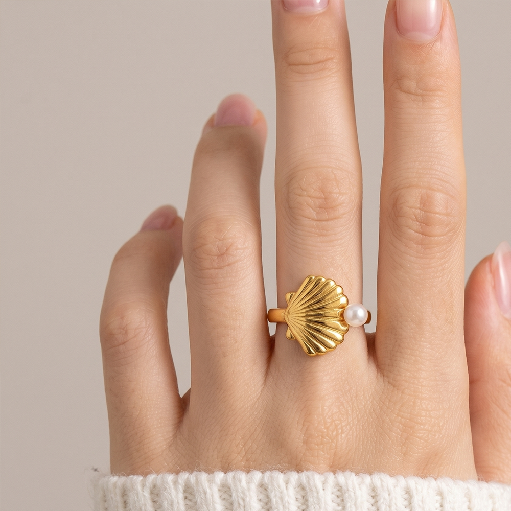 The scallop shell ring worn on the hand, showing how the shell sits across the finger