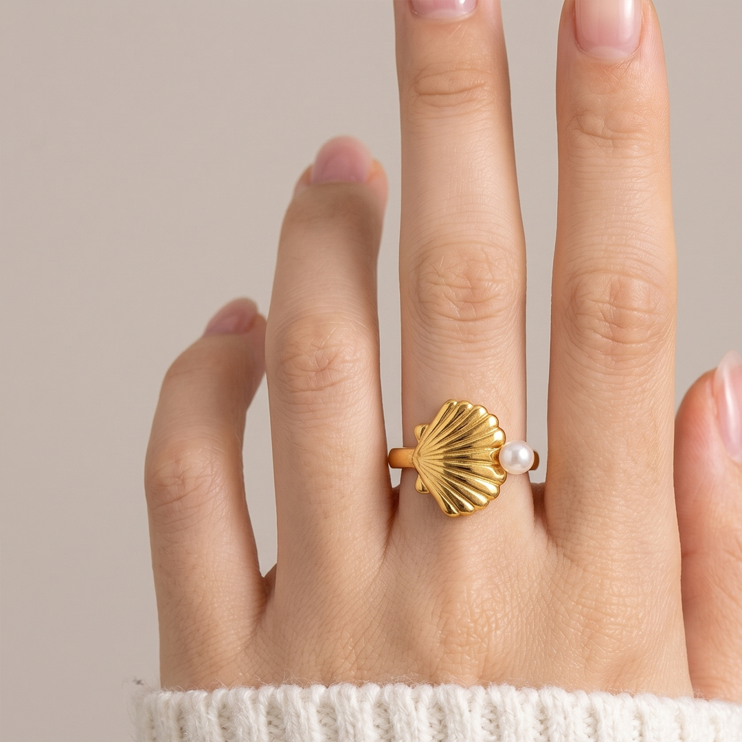 The scallop shell ring worn on the hand, showing how the shell sits across the finger