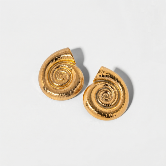 A pair of gold-tone spiral shell stud earrings on a plain background