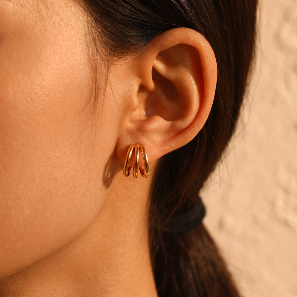 A triple hoop earring worn, showing the three hoops fanning out from the lobe