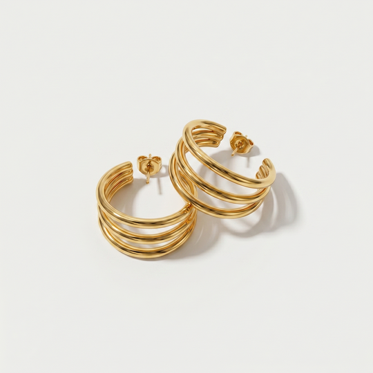 A pair of gold-tone triple hoop earrings, three slim hoops on one post, on a plain background