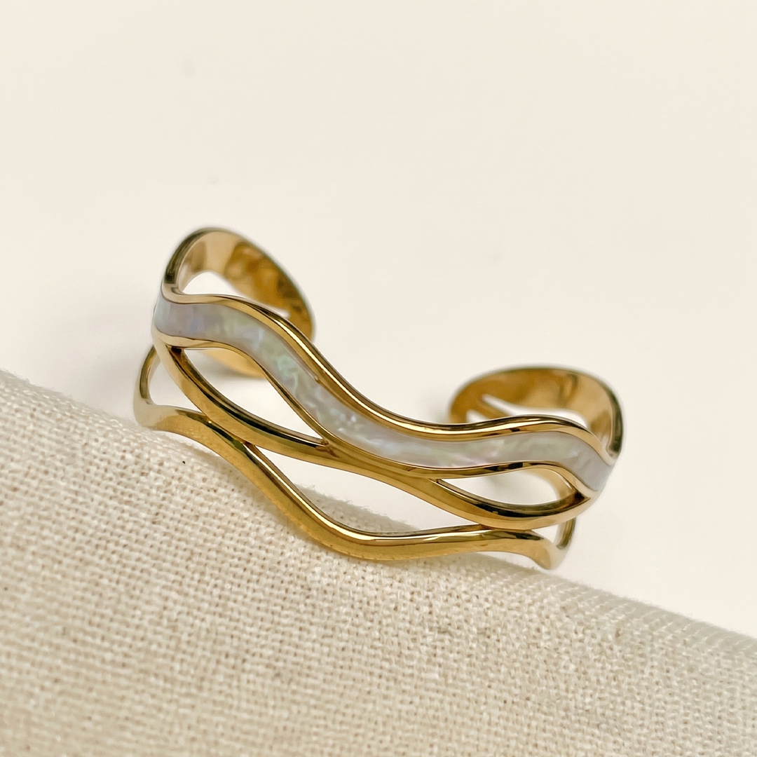 The wave cuff resting on cream silk