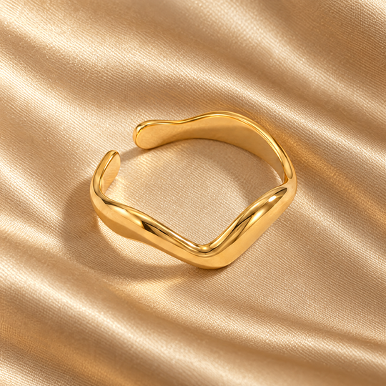 The Vela Wave Ring resting on champagne satin