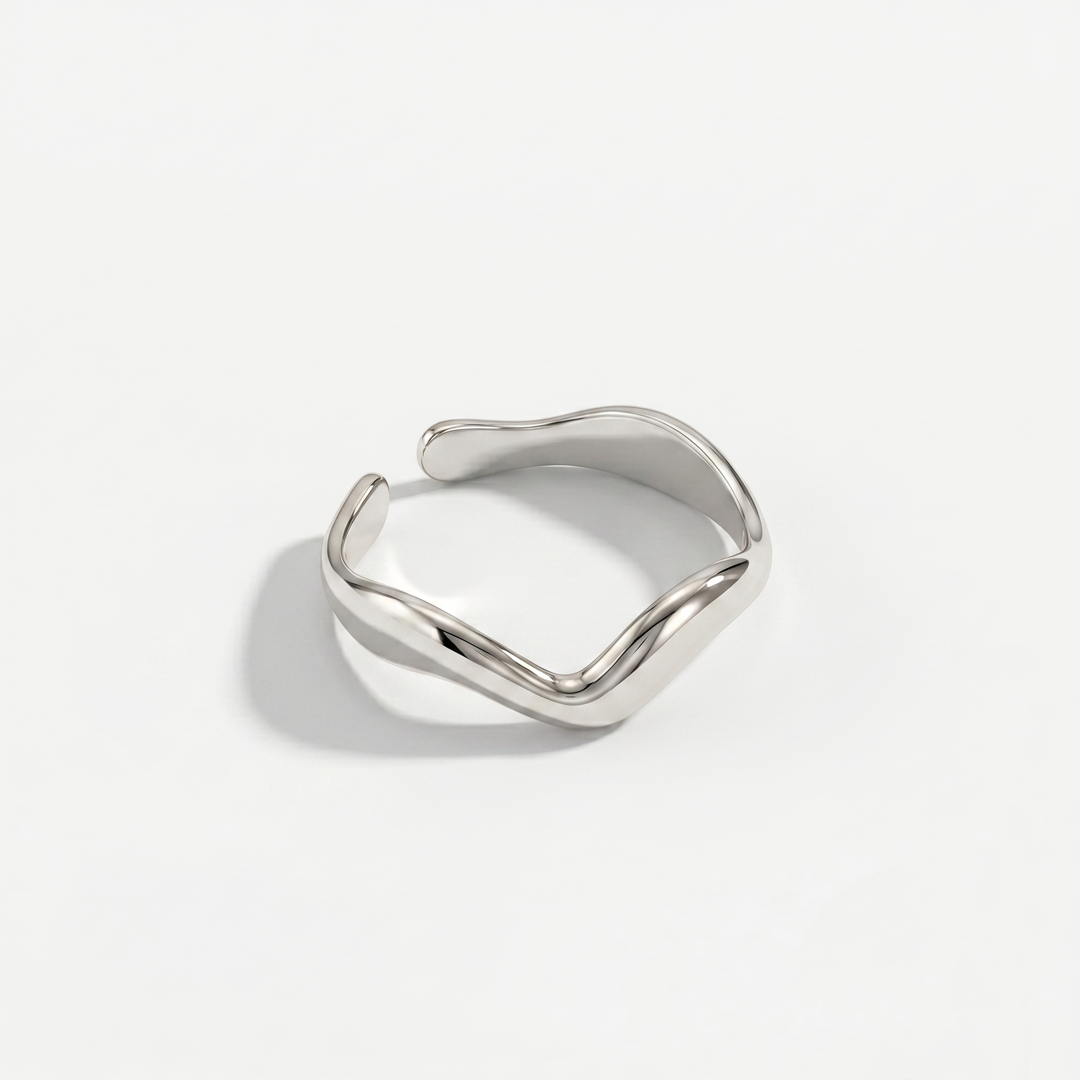The wave-shaped open ring in silver-tone stainless steel, on a plain background