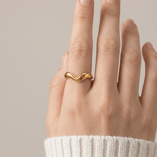 The wave ring worn on the hand, showing how the curved band sits on the finger
