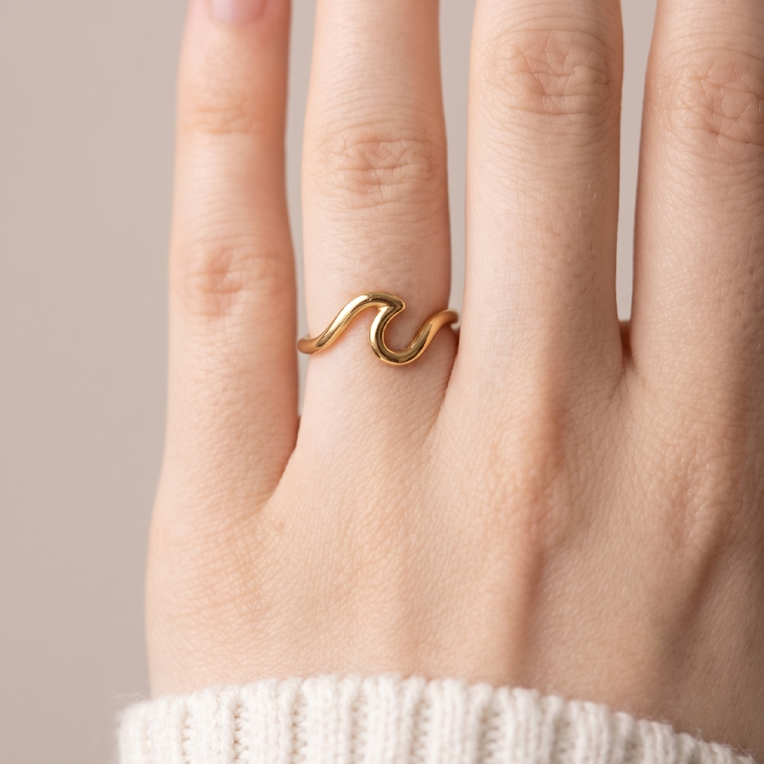 The gold-tone wave ring worn on the hand