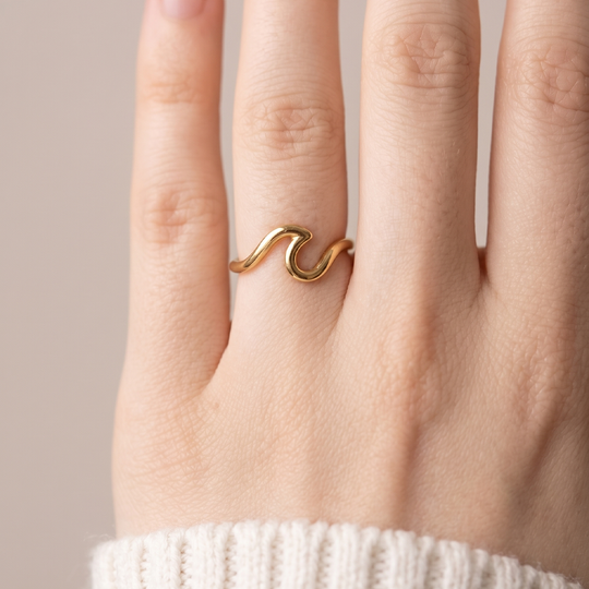 The gold-tone wave ring worn on the hand