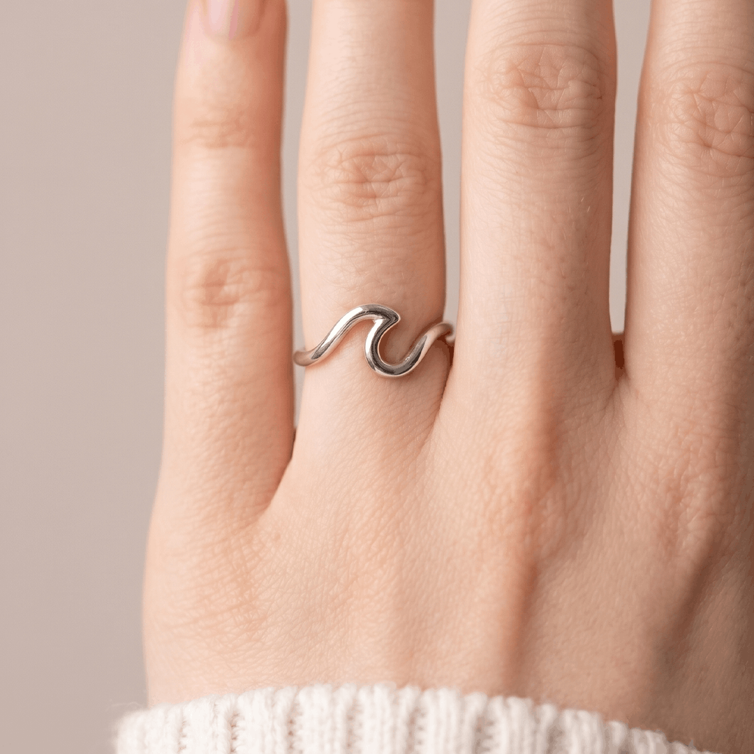 The silver-tone wave ring worn on the hand