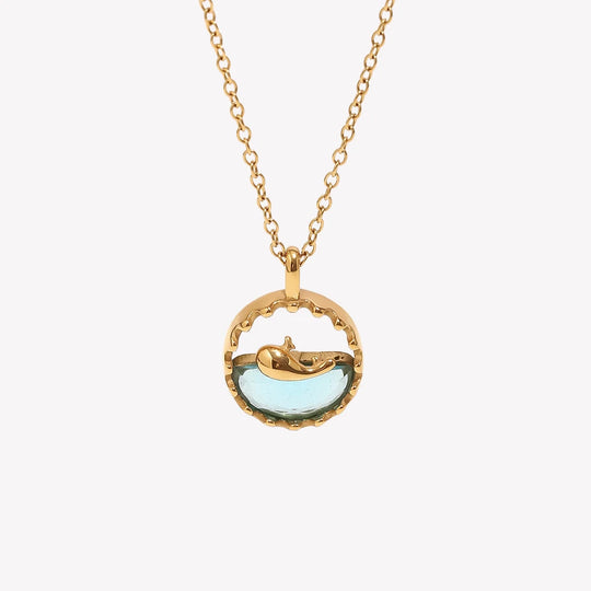 Front view of the whale pendant, showing the blue inlay inside the gold-tone frame