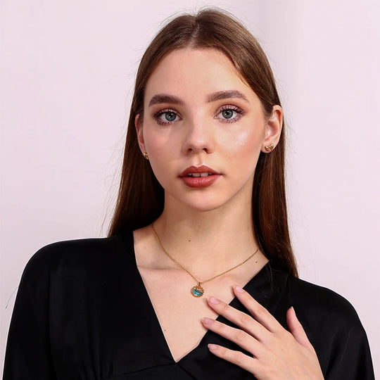 The whale pendant necklace worn, sitting just below the collarbone